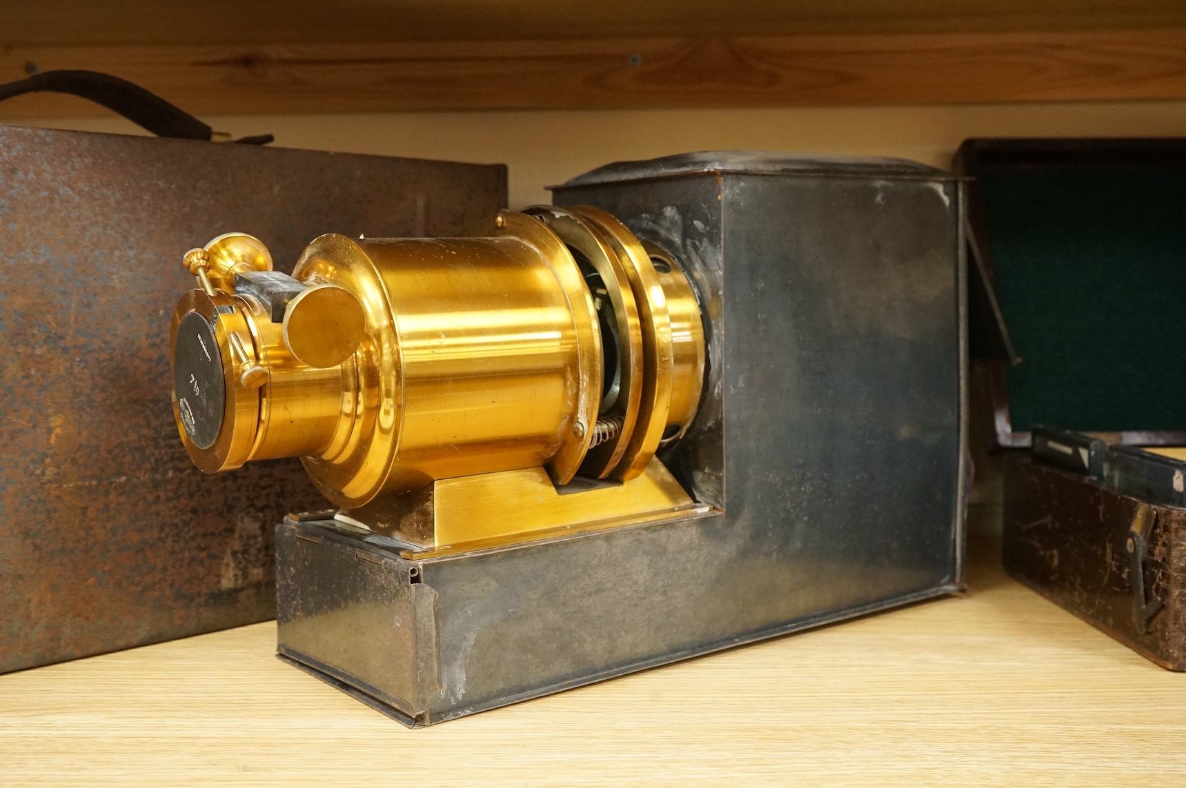 A tinplate and brass magic lantern, converted to an electric lamp and missing the original chimney, in a tin case, together with a case of slides, mostly biblical related.
